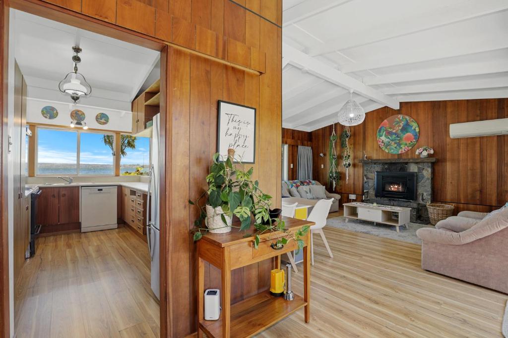 罗托鲁瓦Hannah's Bay Lakefront的厨房以及带木镶板的客厅。