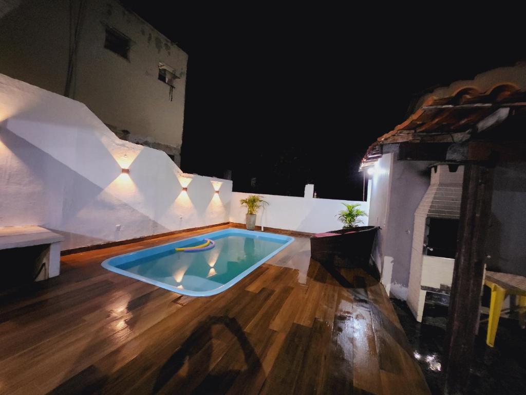 萨夸雷马Casa piscina 8 pessoas的游泳池在晚上位于房子的地板上