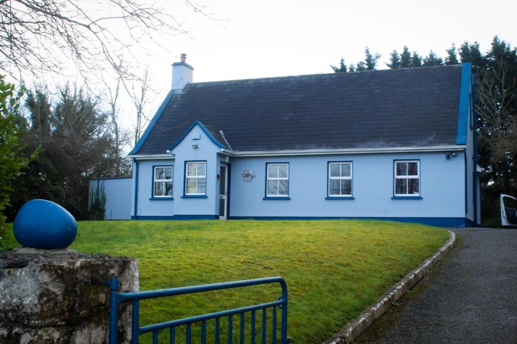CorrofinRiverside Cottage in the Burren的蓝色房子,有黑色屋顶