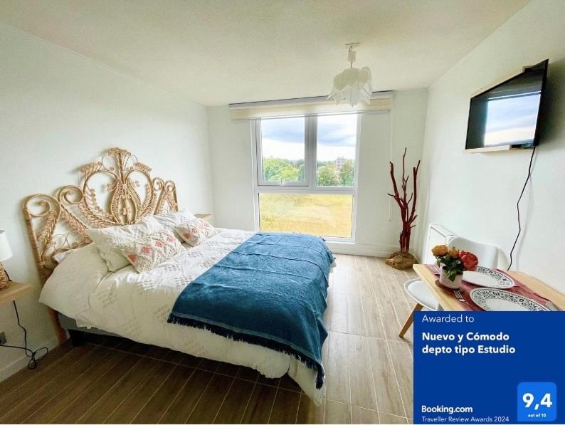瓦尔迪维亚Nuevo y Cómodo depto tipo Estudio的一间卧室配有一张带蓝色毯子的床和窗户。