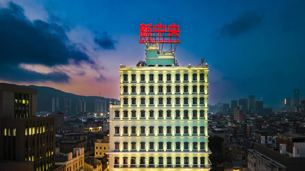 澳门Hotel Central Macau的一座白色的大建筑,上面有标志