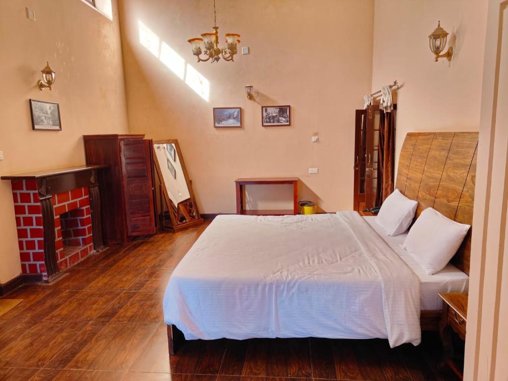 乌提Heritage Inn by Brown Tree Resorts的卧室配有白色的床和壁炉