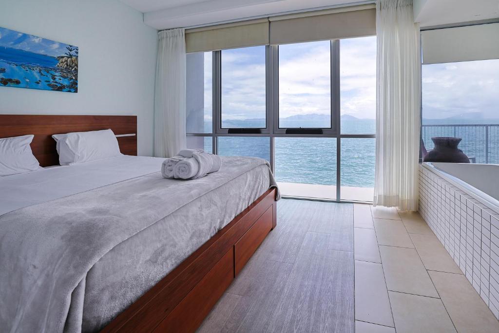 耐莉湾Best at Bright Point Absolute Waterfront Apartment的一间卧室设有一张床,享有海景