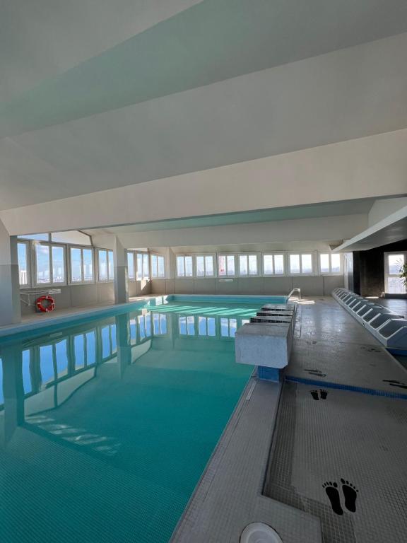 巴黎Suite Bella vista : piscine & vue panoramique的一座大型游泳池,位于一座建筑中,拥有绿色的海水