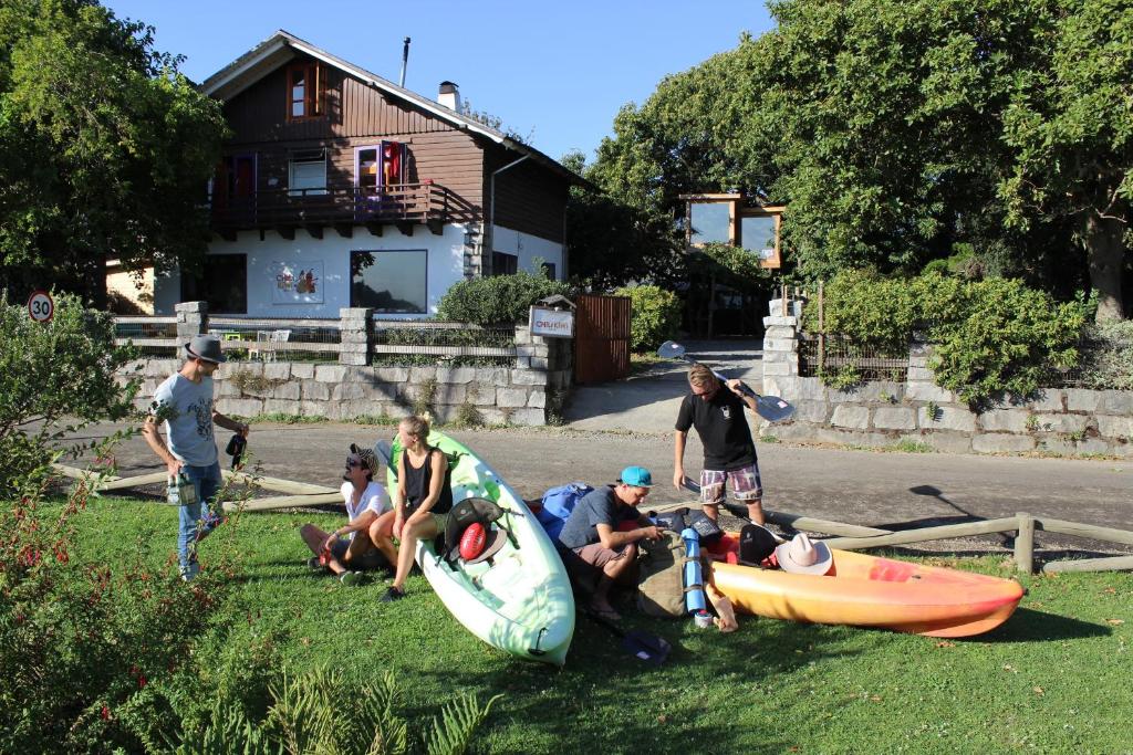 普孔智利几维湖畔背包客旅舍的一群人坐在草地上,划皮艇