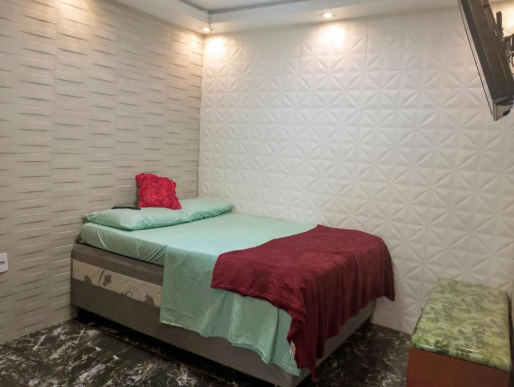 里约热内卢kitnet próximo a praia的一间小卧室,配有一张带红色枕头的床