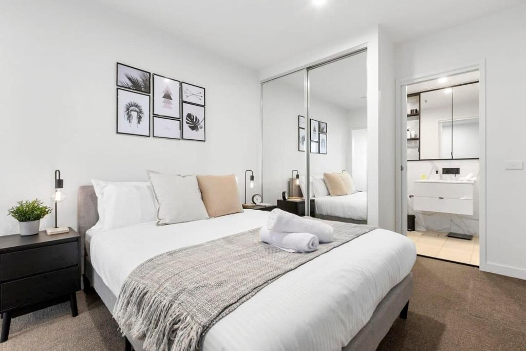 墨尔本Grandeur Apartment的白色的卧室设有一张大床和一间浴室。