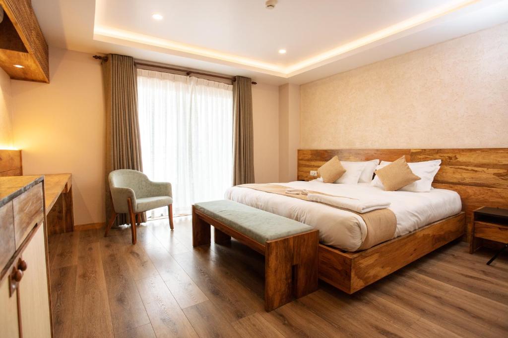 加德满都HOTEL BHRIKUTI TARA的配有一张床和一把椅子的酒店客房