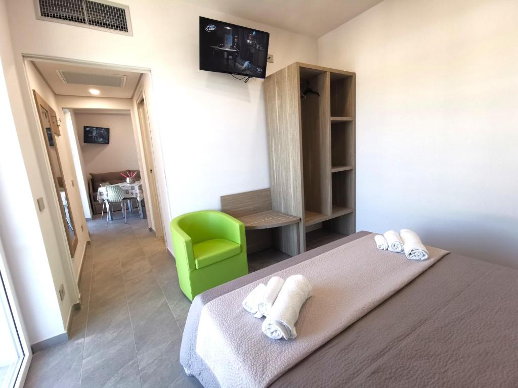 波利卡斯特罗巴森迪诺Resort Policastro的酒店客房,配有一张床和一把绿色椅子