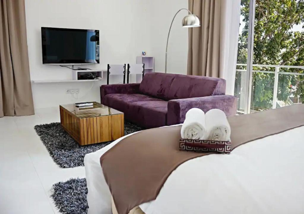 牛汝莪Three Storey Garden Home at Bukit Gambir 18ppl的客厅配有一张床和一张紫色沙发
