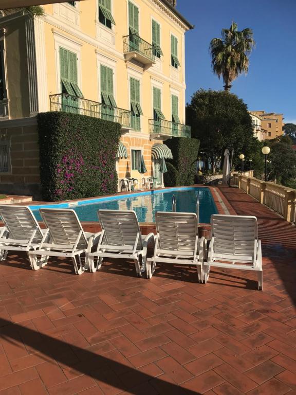 因佩里亚米拉马雷酒店的一组草坪椅,坐在游泳池旁