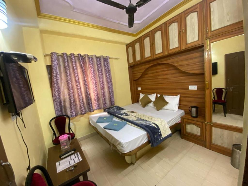 西姆拉BNB ROYAL INN SHIMLA的一间卧室配有一张床和一台电视。