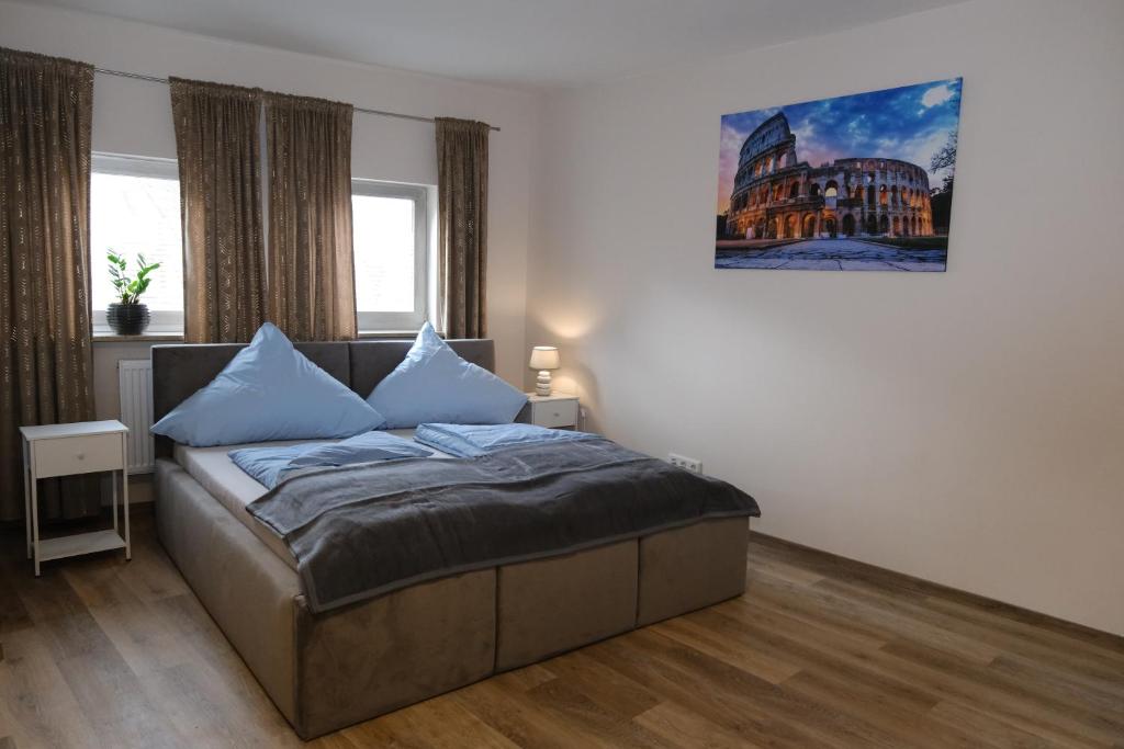 佩格尼茨河畔劳夫Schloss Casa Lauf an der Pegnitz Rom的一间卧室配有一张带蓝色枕头的床。