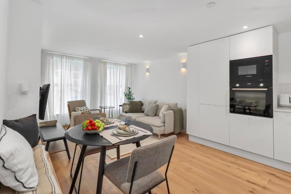 伊斯特布恩Chic Urban Retreat: Modern Apartment in Eastbourne的客厅配有沙发和桌子。
