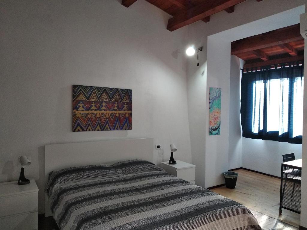 A casa di Pietro的卧室配有一张床,墙上挂有绘画作品