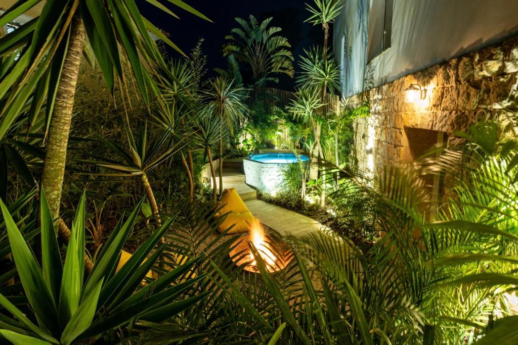 圣维森特费雷拉Azor Eco Lodge的一座花园,位于一座建筑的中间,设有大浴缸