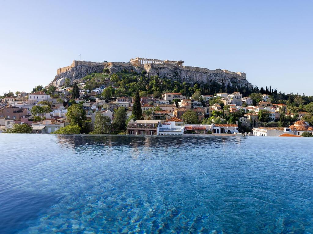 雅典The Dolli at Acropolis的山丘上一座城镇的一大片水体