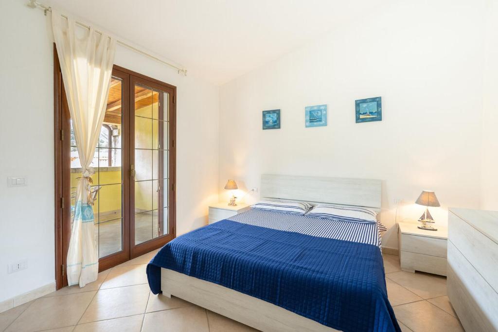 圣特奥多罗Angel Village的白色卧室设有蓝色的床和窗户