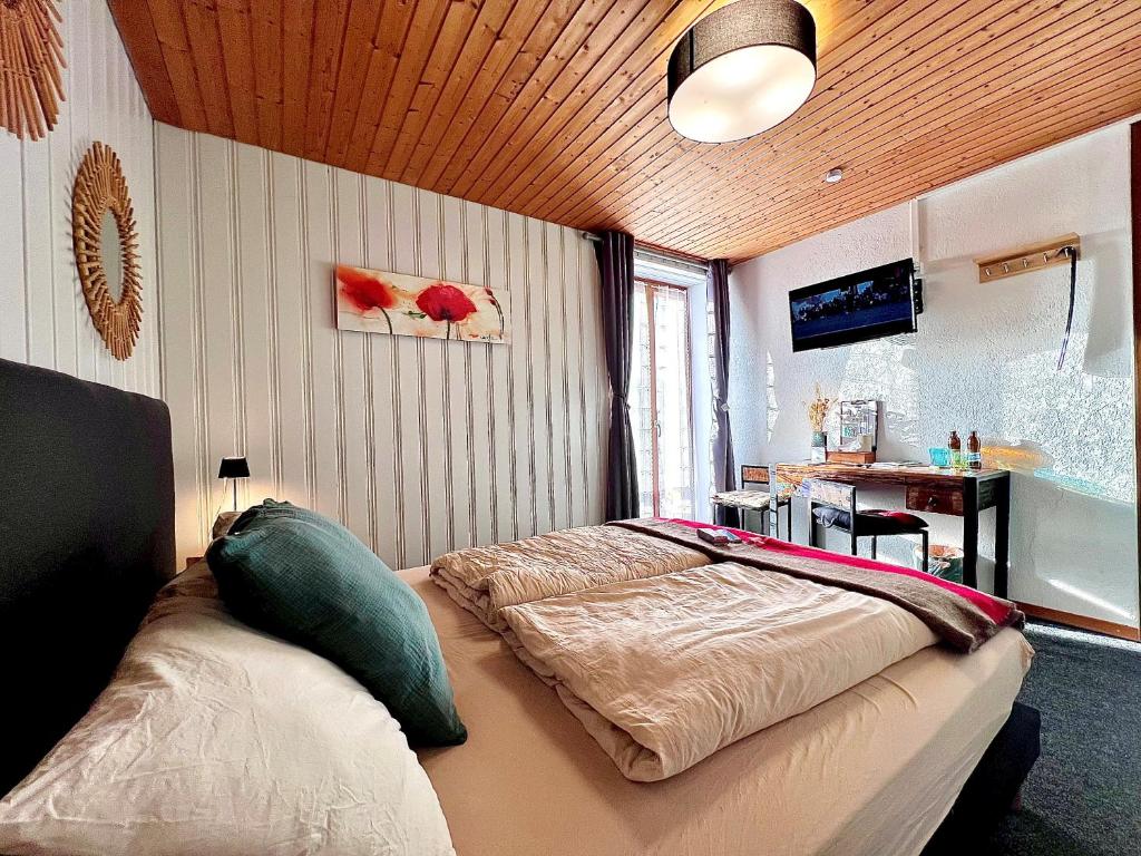 Les VerrièresHôtel Restaurant Les Cernets Swiss-Lodge SSH的一间卧室配有一张床和一张书桌