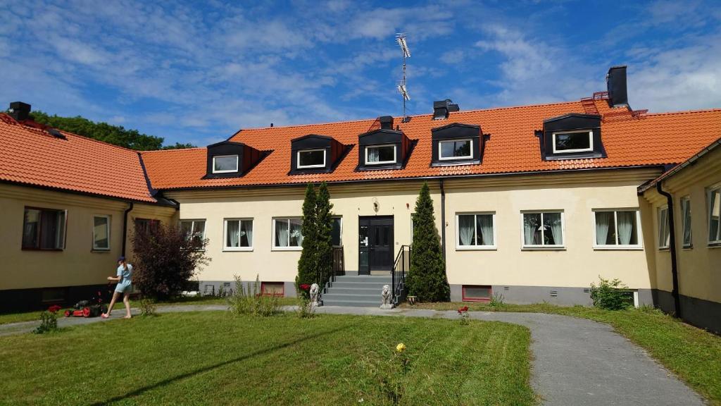 LjugarnEkängens Pensionat Garde的一座白色的大建筑,有橙色的屋顶