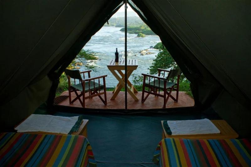 金贾Explorers River Camp的一个带桌椅的海景帐篷