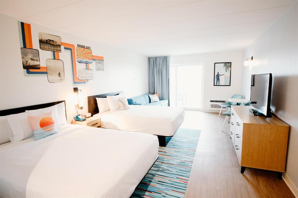 大洋城SeaLoft Oceanfront Hotel的酒店客房设有两张床和一台平面电视。