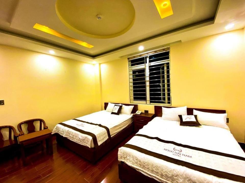 Nhơn TrạchNgọc Hải Nam Hotel - Khách Sạn Nhơn Trạch的黄色墙壁客房的两张床