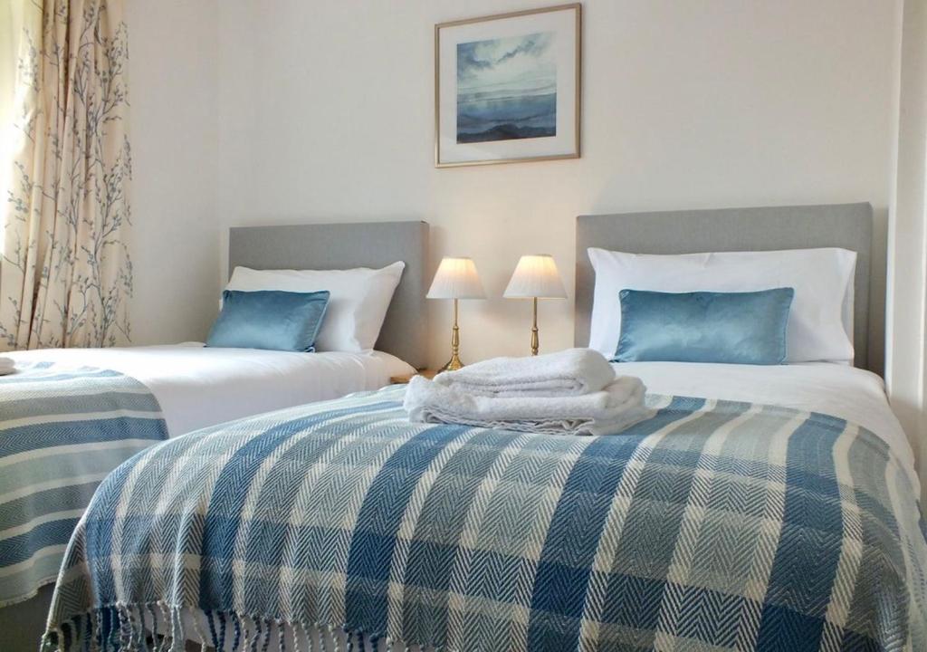 卡迪夫Port View House By Urban Hideaways的一间卧室配有两张带蓝白色床单的床