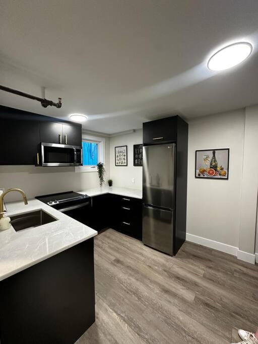 哈利法克斯Quaint Queen Suite Central HFX的厨房配有黑色橱柜和不锈钢冰箱
