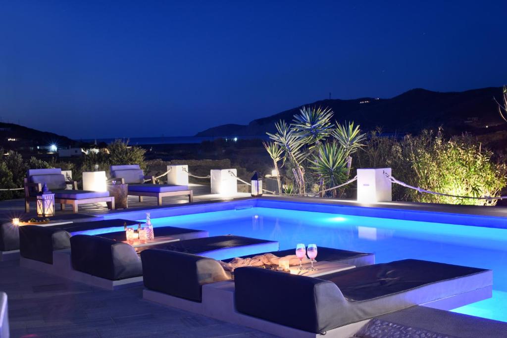 法蒂亚Mykonos Dream Villas的夜间带桌椅的游泳池