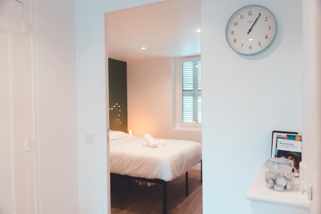 图尔Agréable T2 - Jardin botanique的卧室配有一张床,墙上挂着一个钟