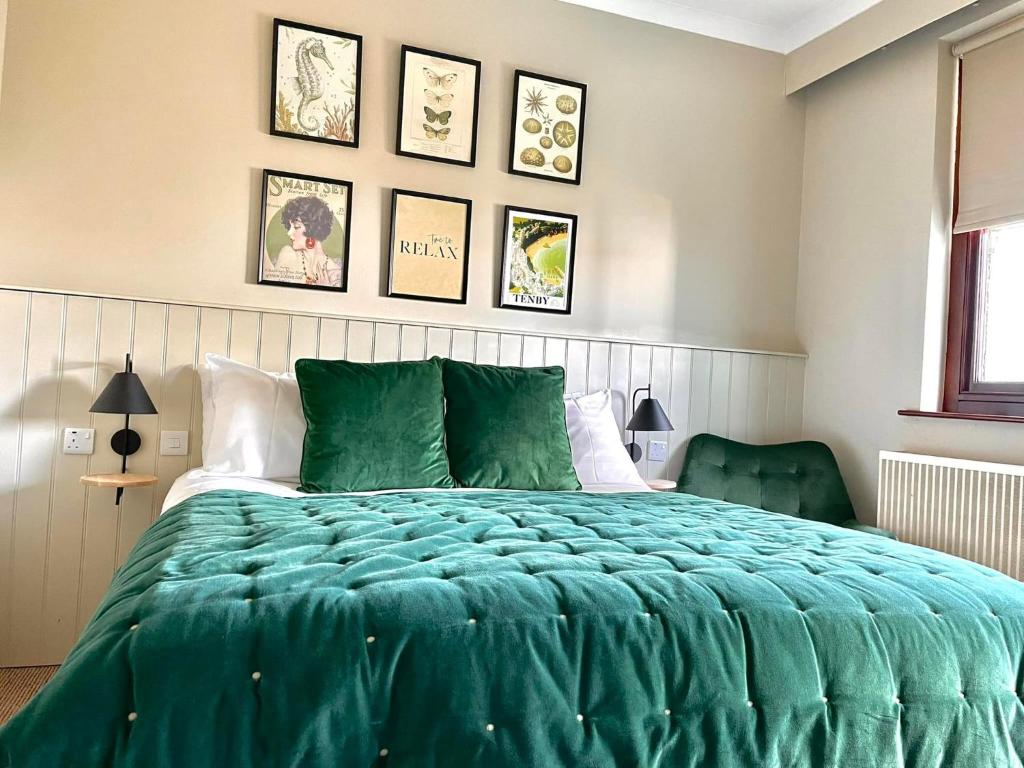 滕比滨海大道1号酒店的一间卧室配有一张带绿色棉被的床