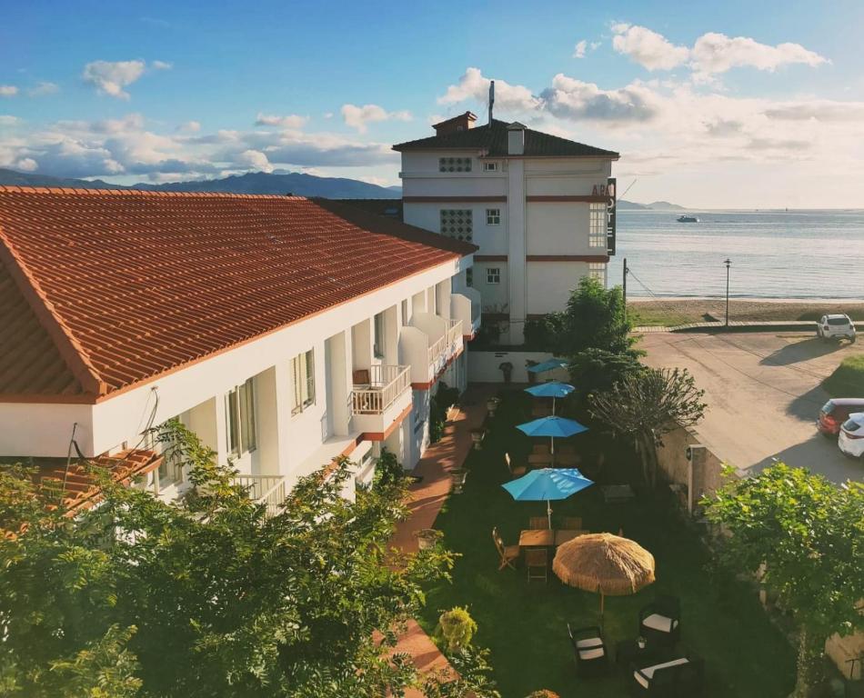 坎加斯德穆拉索罗德拉米尔2A酒店的享有带遮阳伞和大海的建筑景致