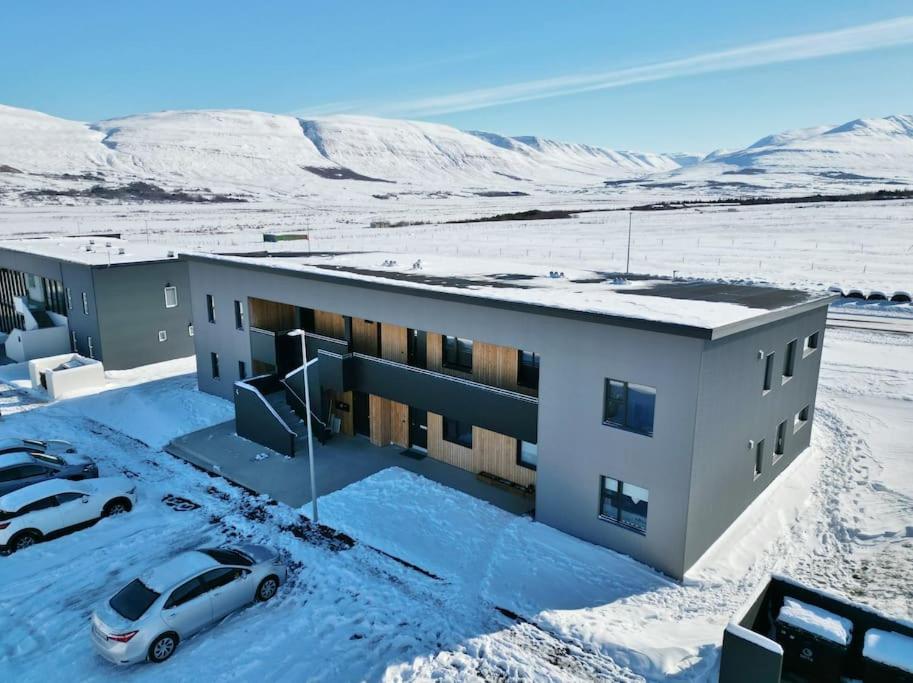 阿克雷里Beautiful apartment in Akureyri的雪地里停着汽车的建筑物