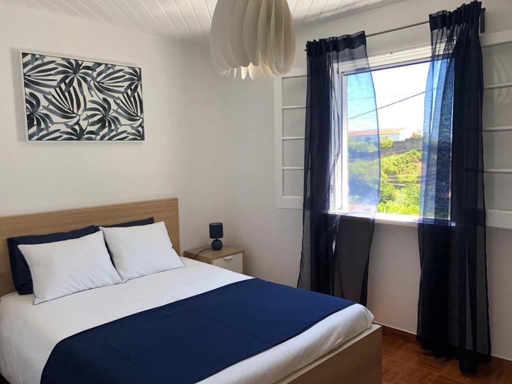 卡罗拉WelcomeBuddy - Uma Casa na Caloura - Blue & Beach的一间卧室设有一张床和一个窗口