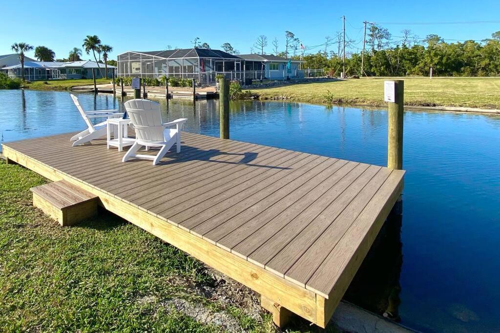 迈尔斯堡Waterfront Gulf Gateway: Pool/Dock/Grill/Gameroom的两把白色椅子坐在水面上的木甲板上