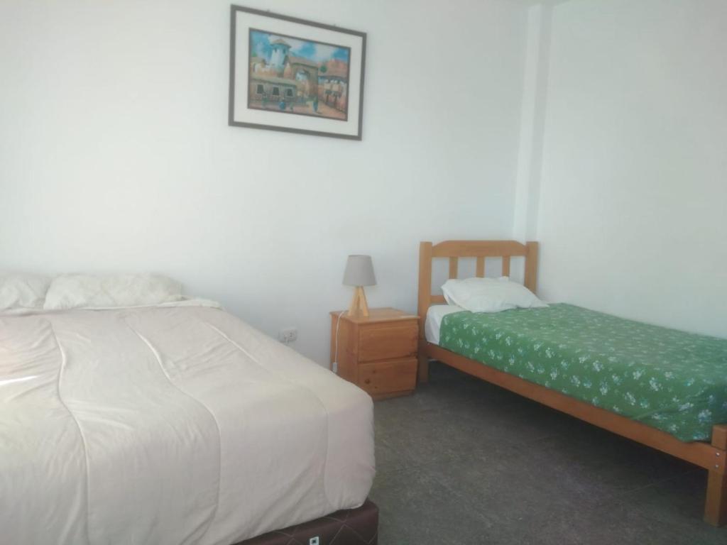 帕拉卡斯HOSPEDAJE PARACAS SUR的一间卧室设有两张床和床头柜