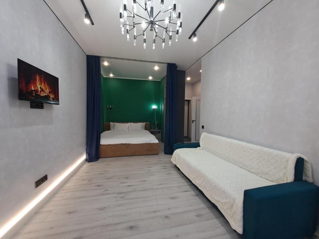 阿斯塔纳INJU Arena 1-rooms apartments的一间卧室配有一张床和一个吊灯