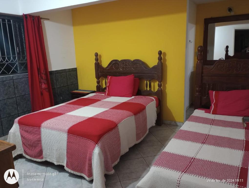 圣若昂-德雷Raio de Sol的一间卧室配有两张红色和白色床单