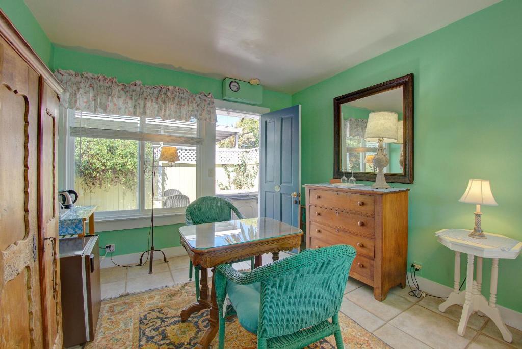 圣巴巴拉秘密花园别墅酒店的一间拥有绿色墙壁和桌椅的用餐室