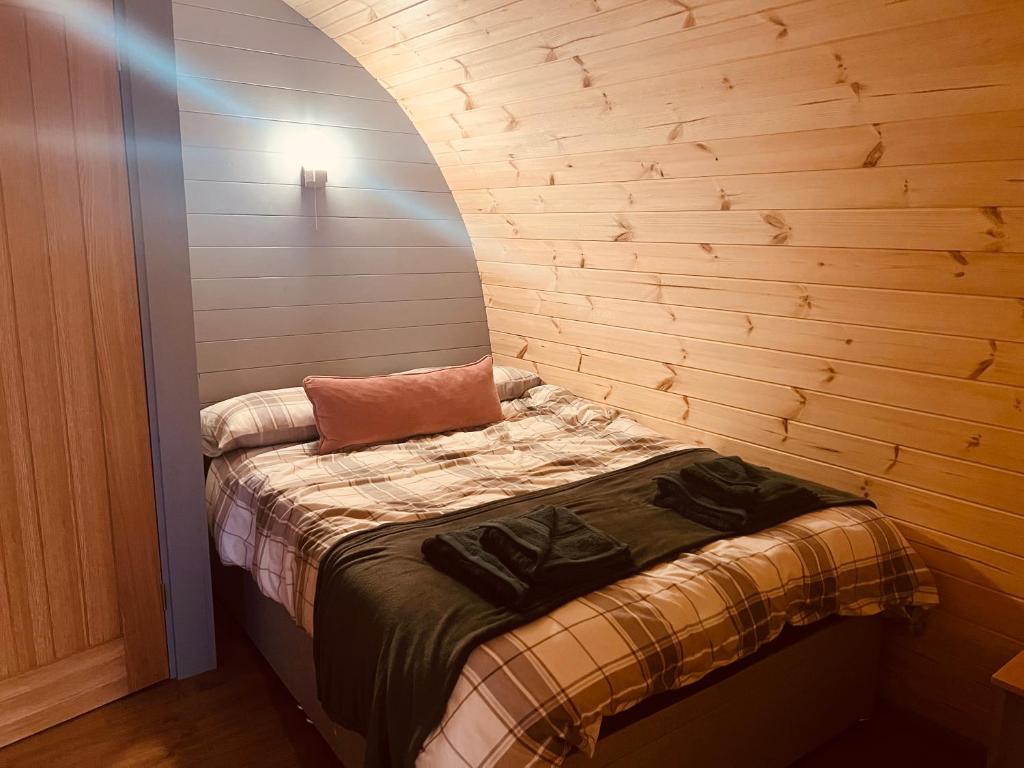 托伯莫里Hidden Hut - Aros View - Tobermory的木墙客房内的小床