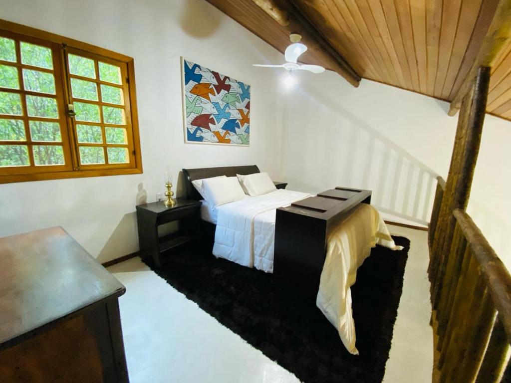 贝洛奥里藏特Casa de Campo Pampulha的一间卧室配有一张床和一张桌子