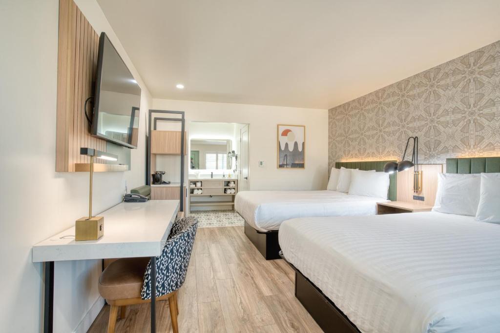 旧金山La Casa Inn的酒店客房配有两张床和一张书桌