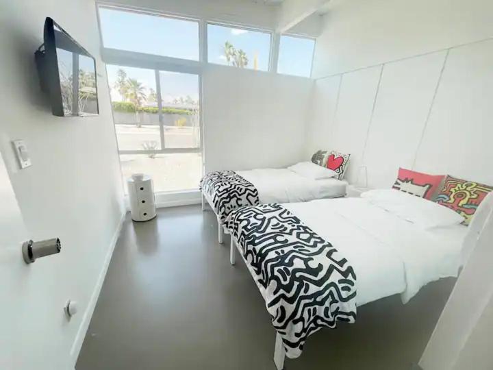 棕榈泉Super Cute room in Architectural Home的一间卧室设有两张床、一台电视和一扇窗户。