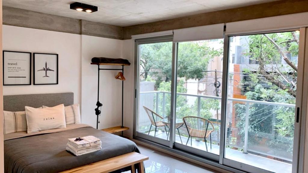 布宜诺斯艾利斯Amazing Apartment in Palermo Hollywood!的一间卧室设有一张床和一个大窗户