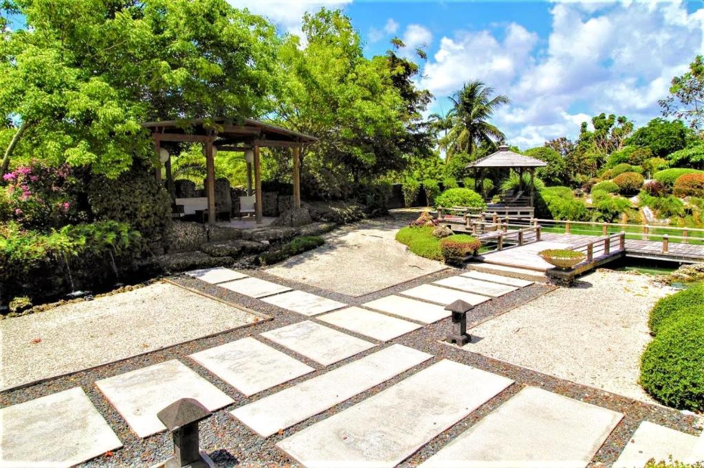 霍姆斯泰德Exotic Sukiya Tiny House Japanese Balinese Gardens的一个带长凳和凉亭的花园