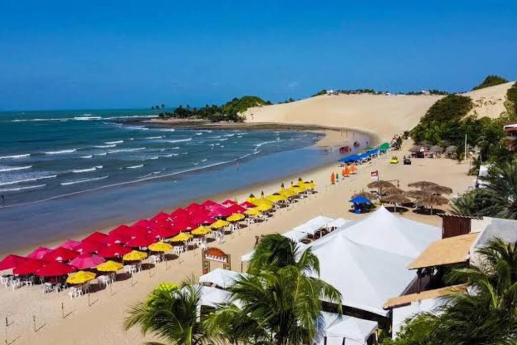 ExtremózCasa em Natal /Extremoz - RN的海滩上摆放着五颜六色的遮阳伞,还有大海