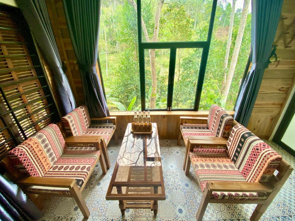 河江Ha Giang Xanh Retreat, Tour and Motorbike Rental的窗户客房内的一组椅子和一张桌子
