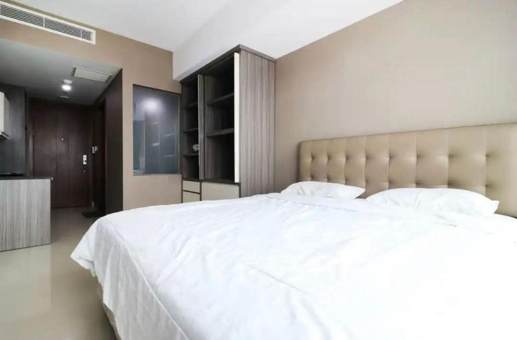 当格浪Collection O 93707 Rooms By U的卧室配有一张大白色的床和大床头板