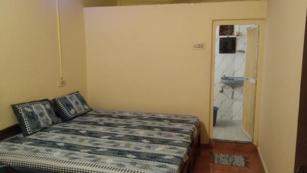 阿姆波尔Laxmi Guest House (Arambol Beach)的一间卧室配有一张床,浴室设有水槽